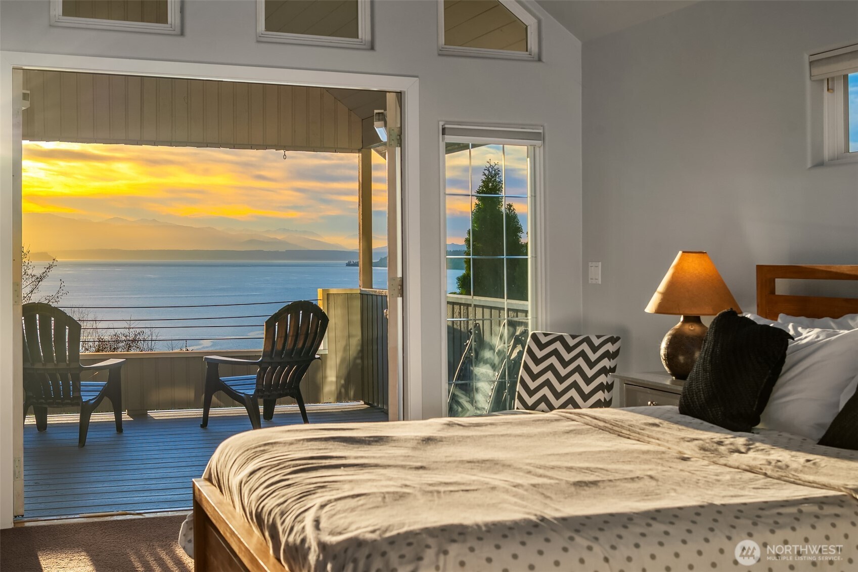 6790 Sills Road Clinton, WA 98236 - Photo 20 of 40 a bedroom with a bed lamp and a large window
