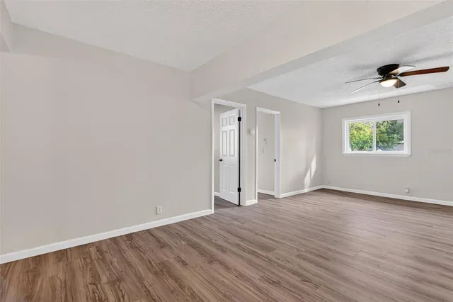 an empty room with a window and a painting