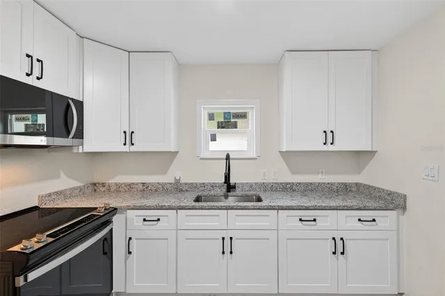 a kitchen with granite countertop a sink and a window