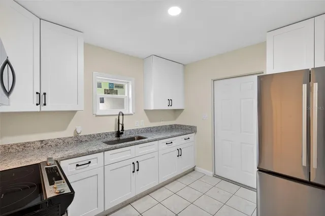a view of kitchen with refrigerator stove and cabinets