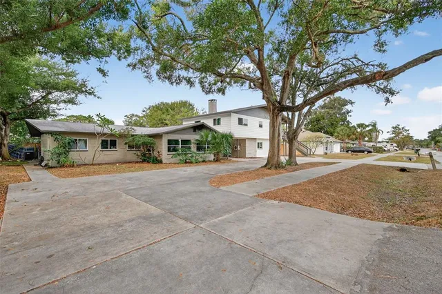 an aerial view of residential houses with outdoor space and trees