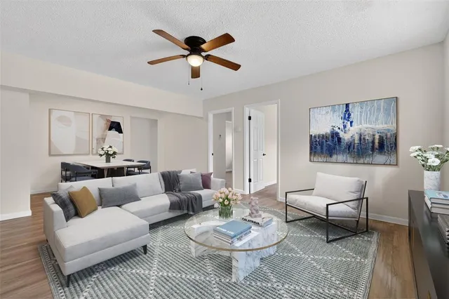 an empty room with wooden floor and ceiling fan