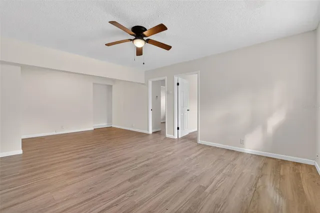 an empty room with wooden floor and mirror