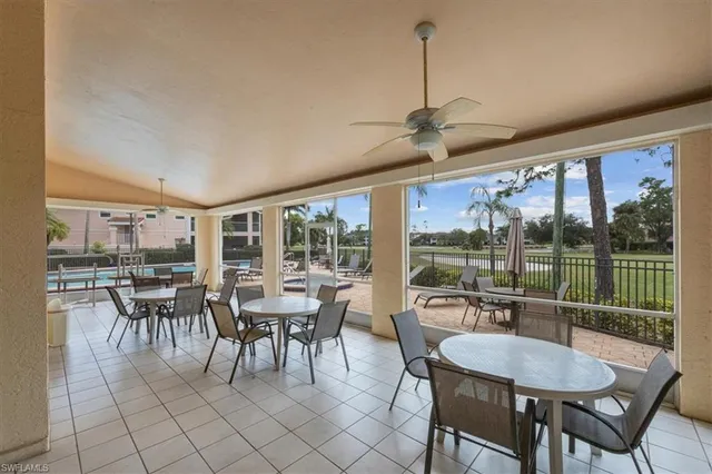 a dining room with furniture water view and a floor to ceiling window
