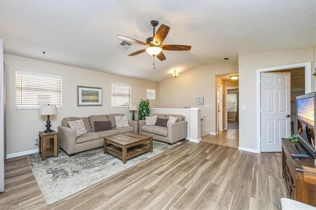 a living room with furniture and a wooden floor