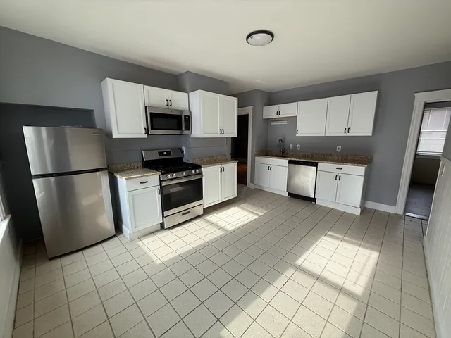 a kitchen with stainless steel appliances granite countertop a refrigerator sink and microwave