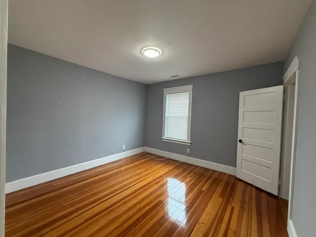 a view of room with window and wooden floor