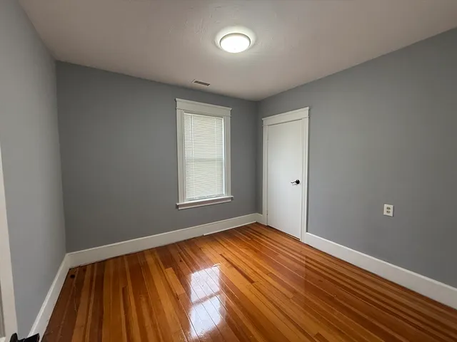 a view of room with window and wooden floor
