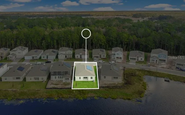 an aerial view of residential houses with outdoor space and lake view