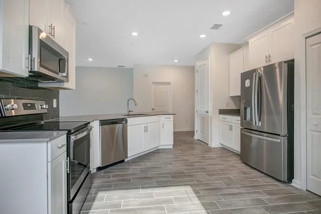 a kitchen with a sink stainless steel appliances and cabinets