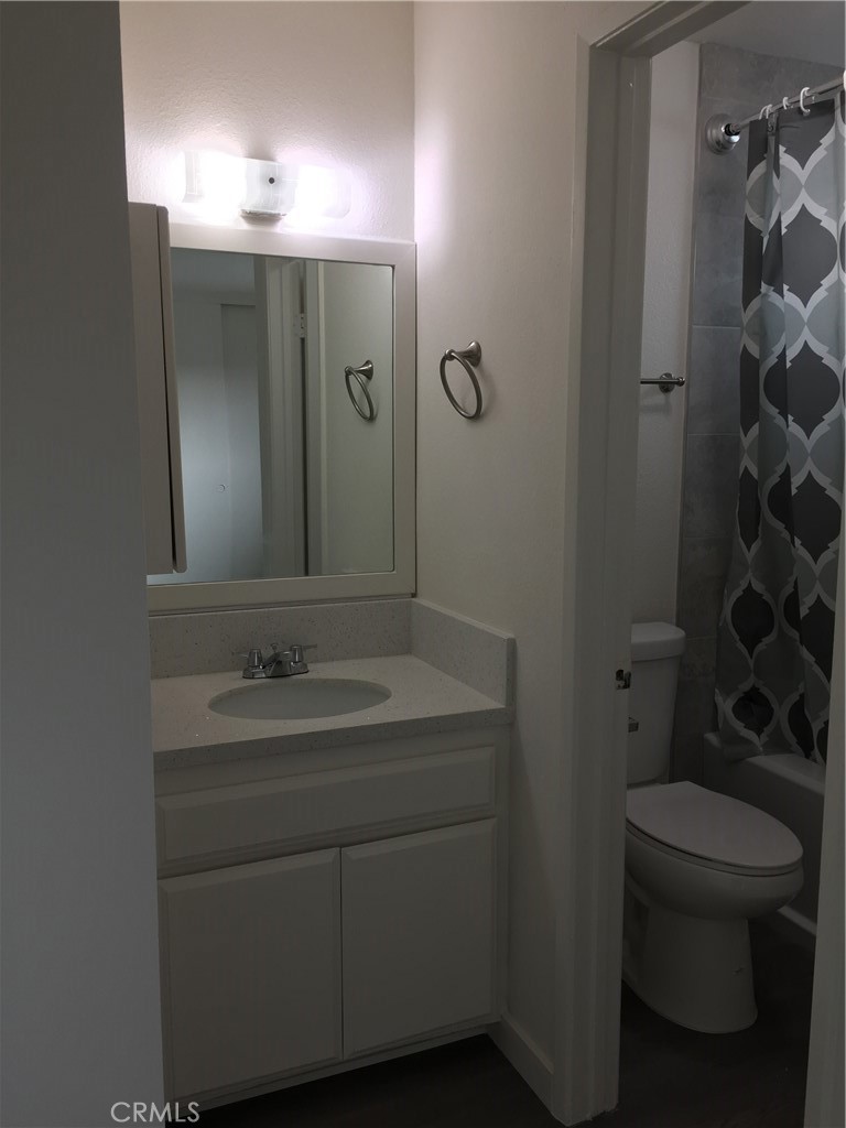 17011 Sims Lane, Unit 6 Huntington Beach, CA 92649 - Photo 12 of 19 a bathroom with a toilet sink and mirror