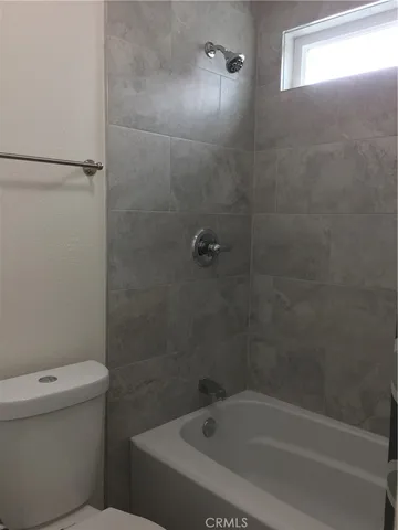 a white bath tub sitting next to a toilet