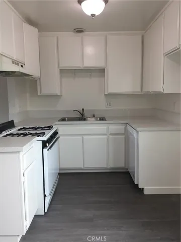 a kitchen with stainless steel appliances granite countertop a sink stove and cabinets