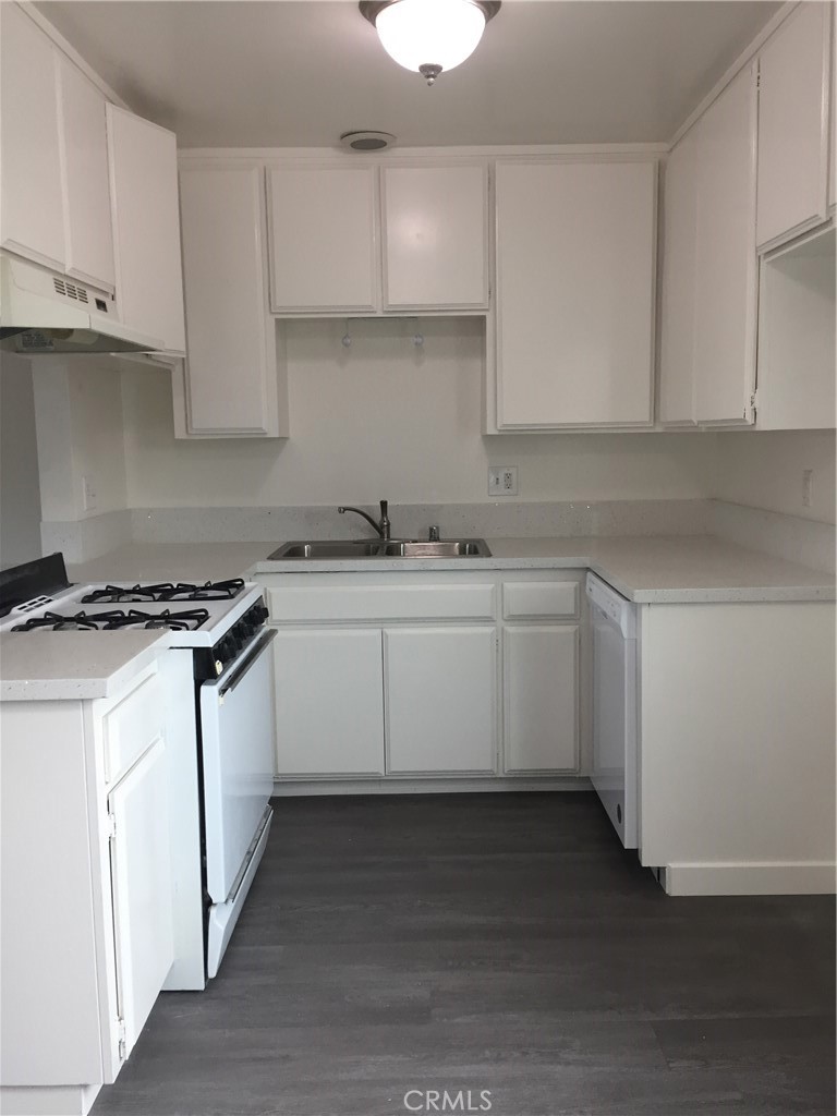 17011 Sims Lane, Unit 6 Huntington Beach, CA 92649 - Photo 3 of 19 a kitchen with stainless steel appliances granite countertop a sink stove and cabinets