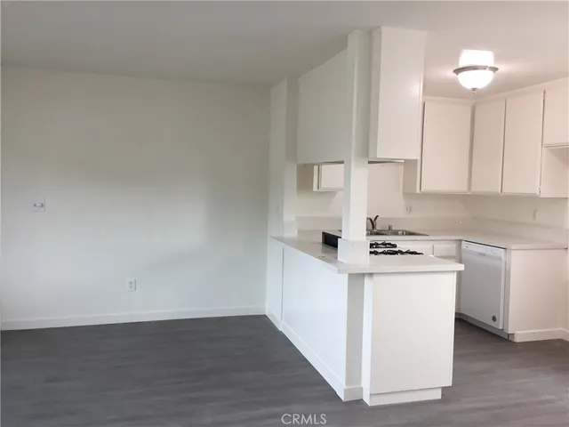a kitchen with cabinets wooden floor and a sink