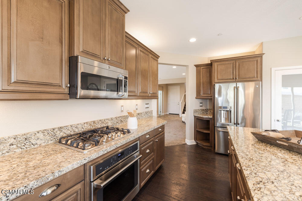 13988 Burdock Drive Moorpark, CA 93021 - Photo 11 of 35 a kitchen with stainless steel appliances granite countertop a stove refrigerator and microwave