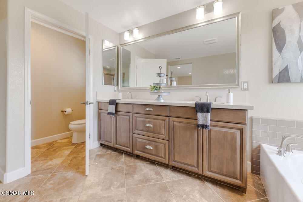 13988 Burdock Drive Moorpark, CA 93021 - Photo 25 of 35 a bathroom with a granite countertop sink a toilet and a mirror