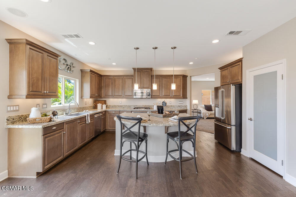 13988 Burdock Drive Moorpark, CA 93021 - Photo 10 of 35 a kitchen with a table chairs refrigerator and microwave