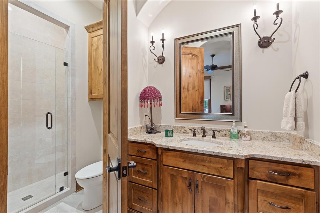 3705 Champions Ridge Lane Longview, TX 75605 - Photo 25 of 40 a bathroom with a granite countertop sink toilet and shower