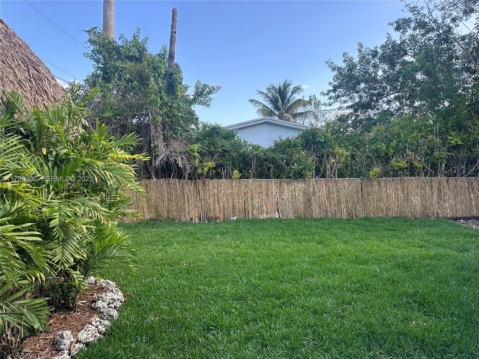 29035 Maine Road Homestead, FL 33033 - Photo 5 of 55 a view of a yard with large trees and wooden fence