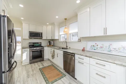 a kitchen with a sink a refrigerator and a stove top oven