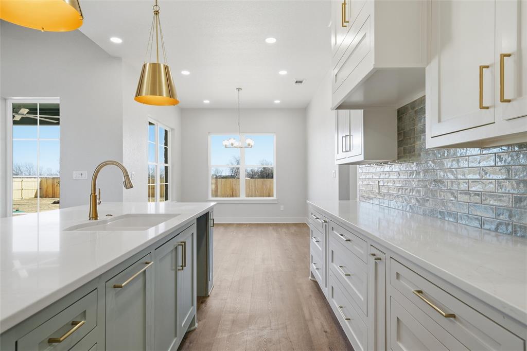 348 Lacek Mill Road China Spring, TX 76633 - Photo 9 of 40 an open kitchen with stainless steel appliances granite countertop a sink a stove and a wooden floors