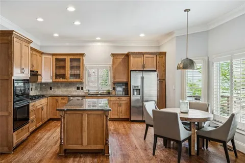 a kitchen with refrigerator a sink and chairs