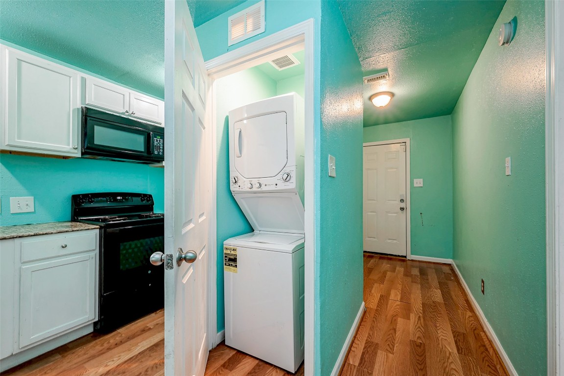 3938 King Street Houston, TX 77026 - Photo 27 of 34 a kitchen with white cabinets and black appliances