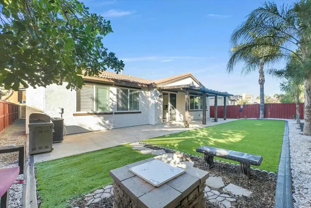 a view of a house with backyard and sitting area