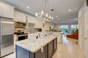 a kitchen with kitchen island a sink counter top space appliances and cabinets