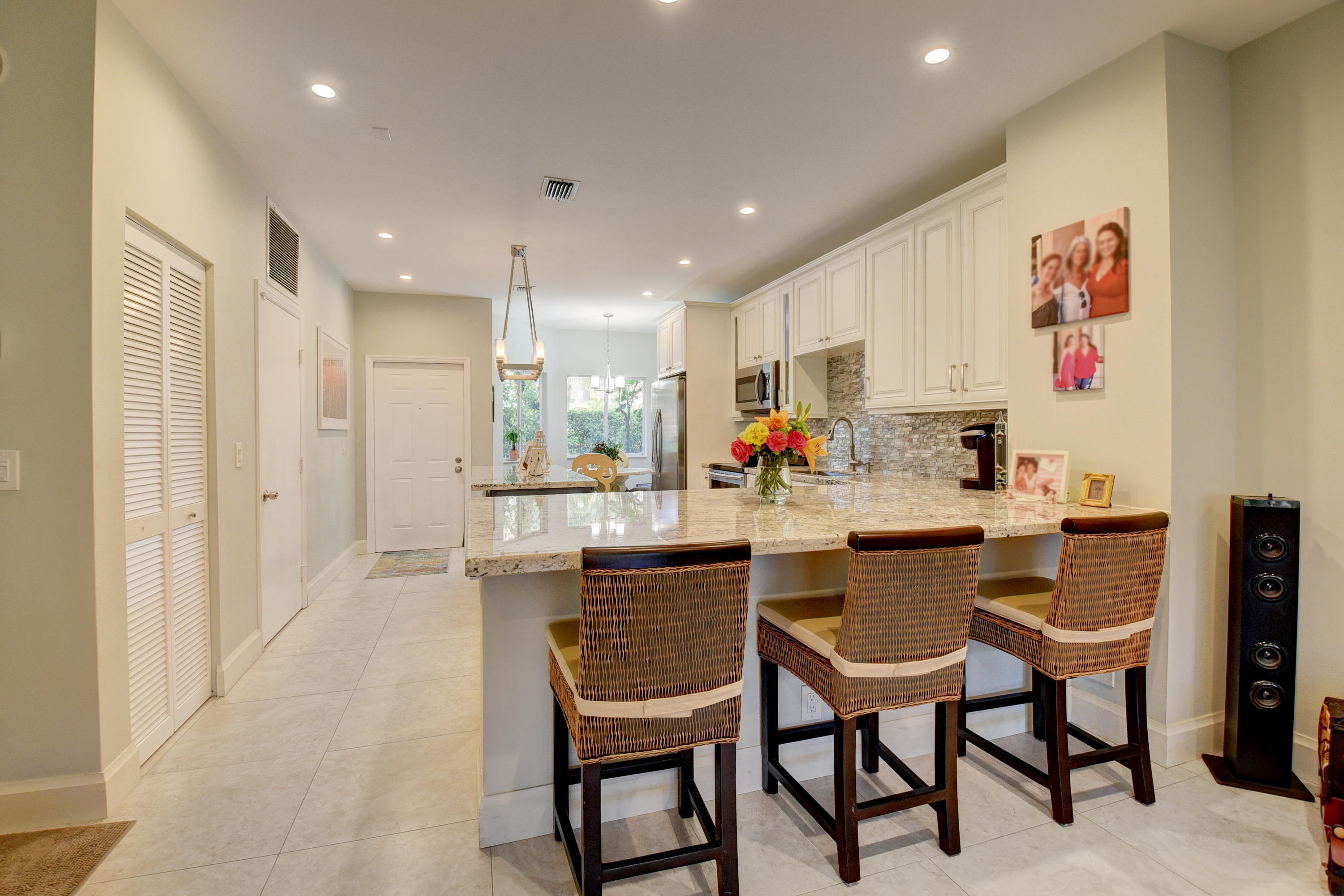 6817 Via Regina Boca Raton, FL 33433 - Photo 12 of 42 a kitchen with a dining table chairs and refrigerator