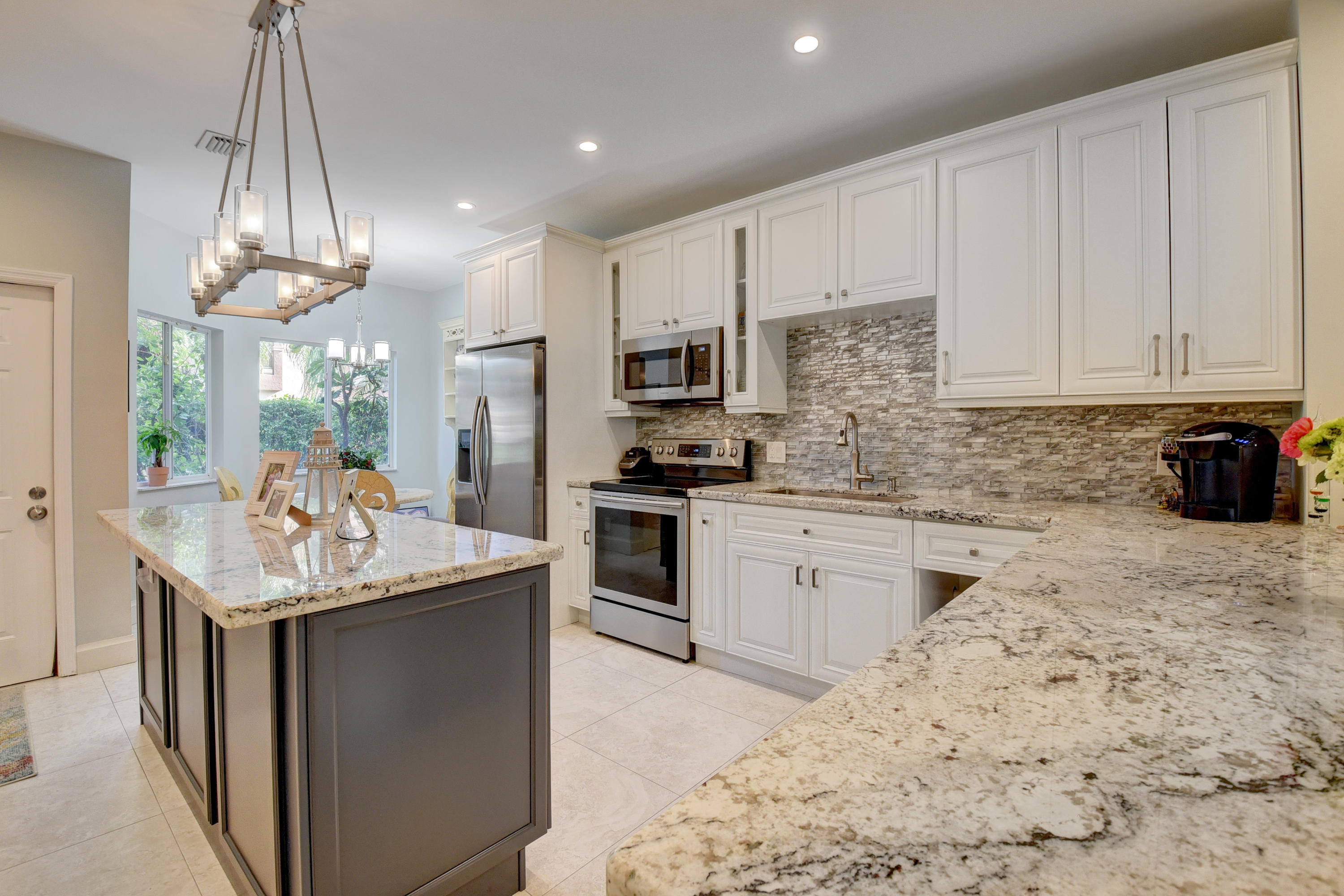 6817 Via Regina Boca Raton, FL 33433 - Photo 13 of 42 a kitchen with stainless steel appliances granite countertop a sink stove and refrigerator