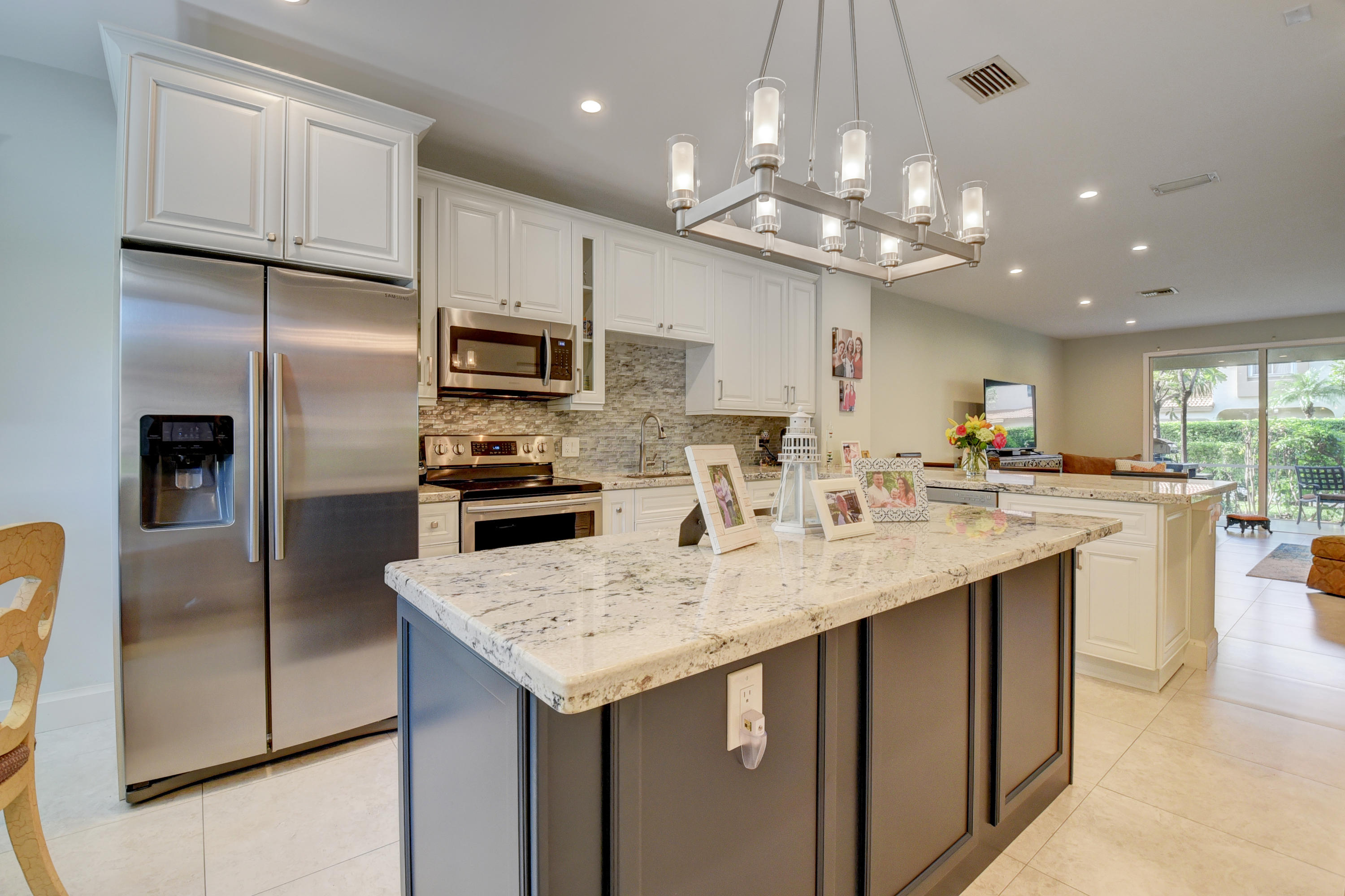 6817 Via Regina Boca Raton, FL 33433 - Photo 16 of 42 a kitchen with stainless steel appliances granite countertop a sink refrigerator and cabinets