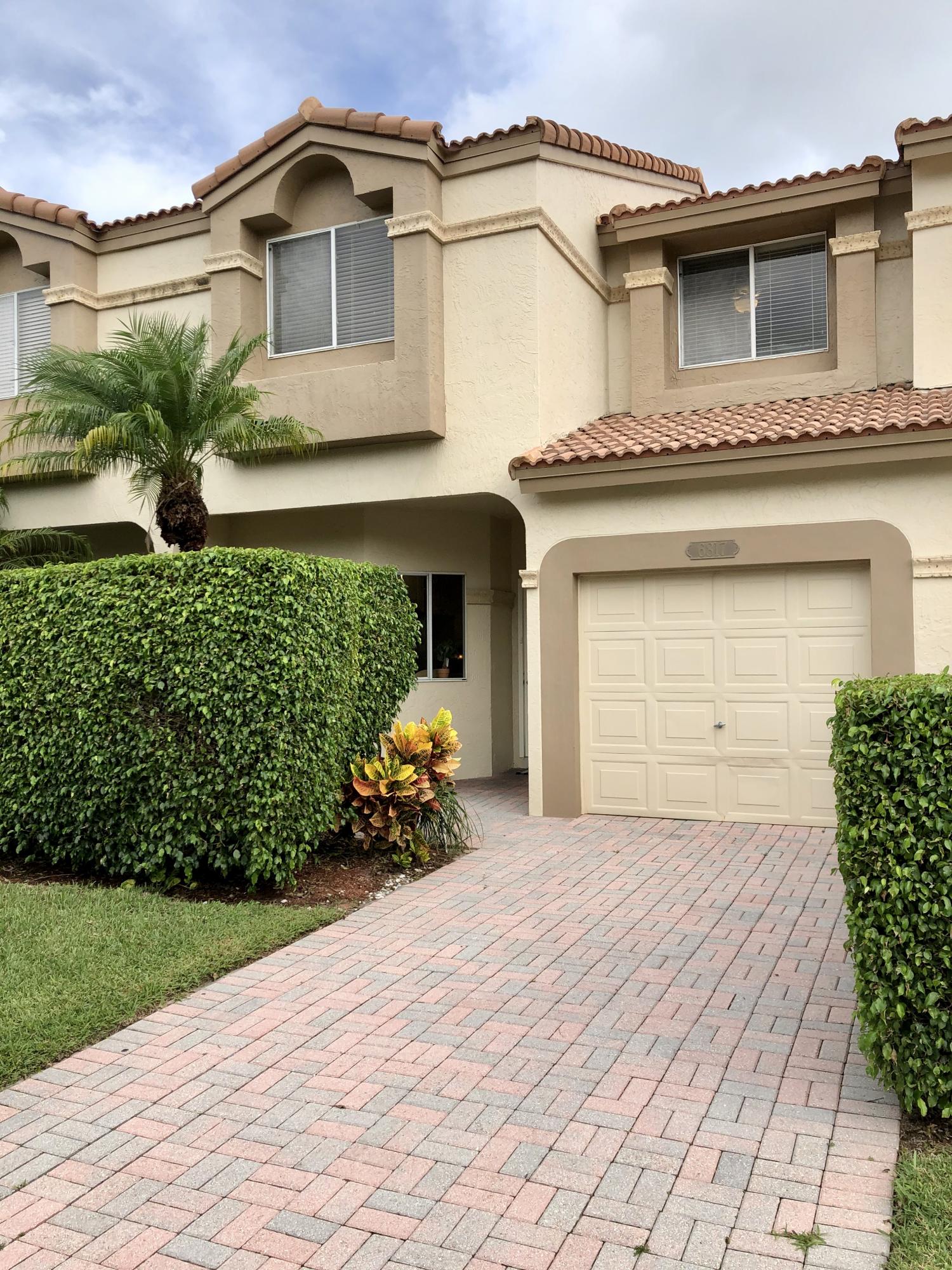 6817 Via Regina Boca Raton, FL 33433 - Photo 2 of 42 a front view of a house with a yard and garage