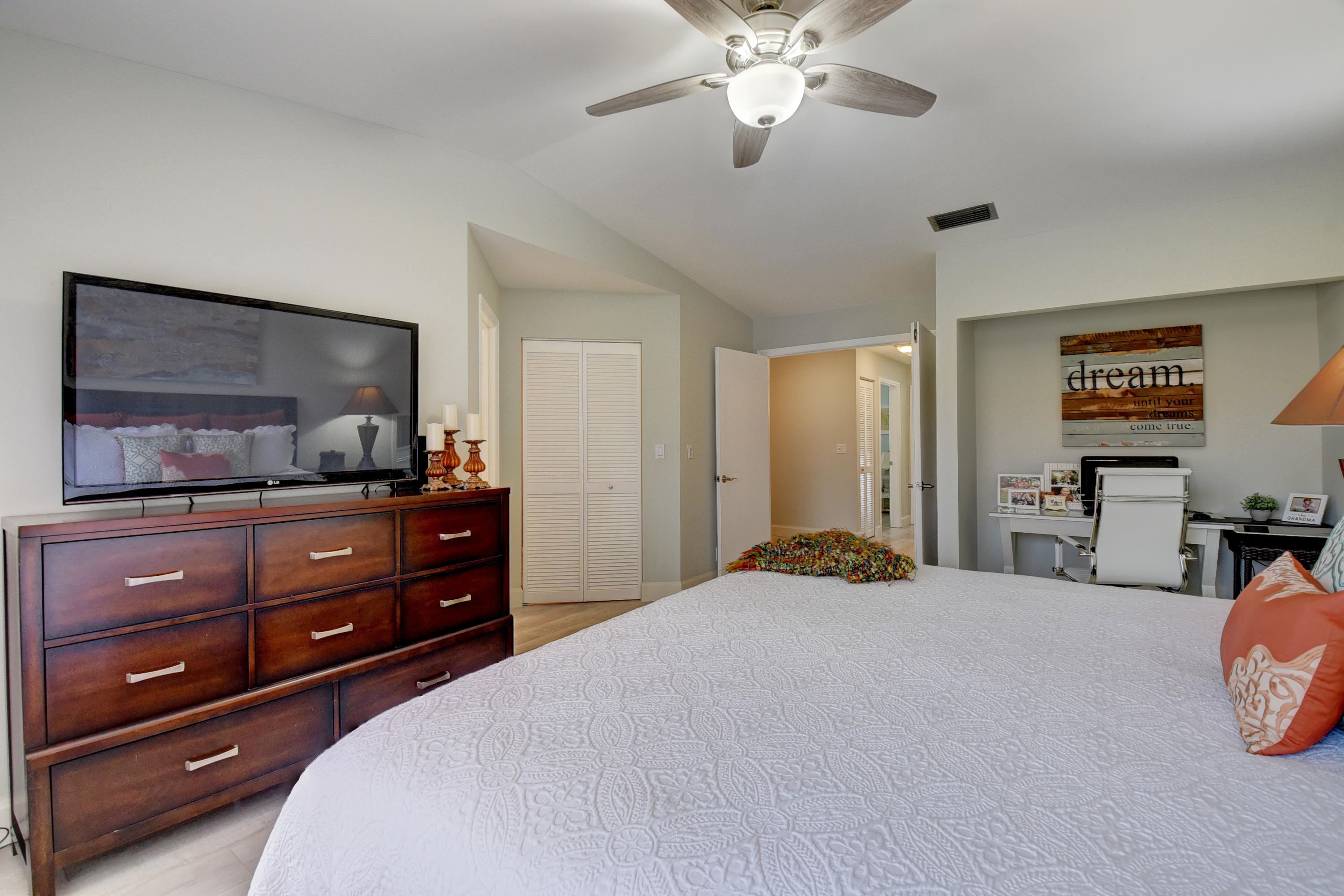 6817 Via Regina Boca Raton, FL 33433 - Photo 21 of 42 a bedroom with a bed and a flat tv screen on dresser