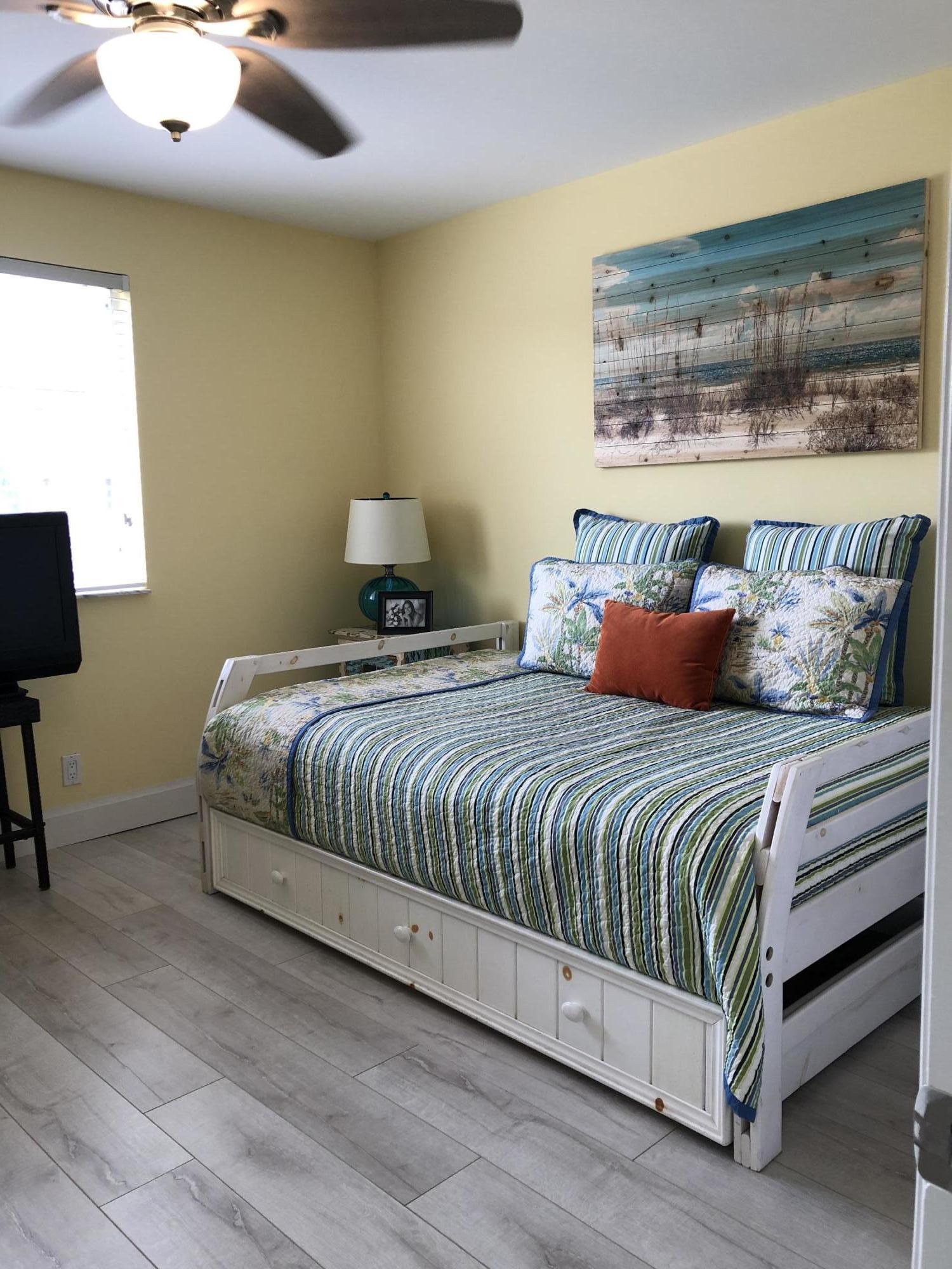 6817 Via Regina Boca Raton, FL 33433 - Photo 27 of 42 a bedroom with a large bed and a lamp on table