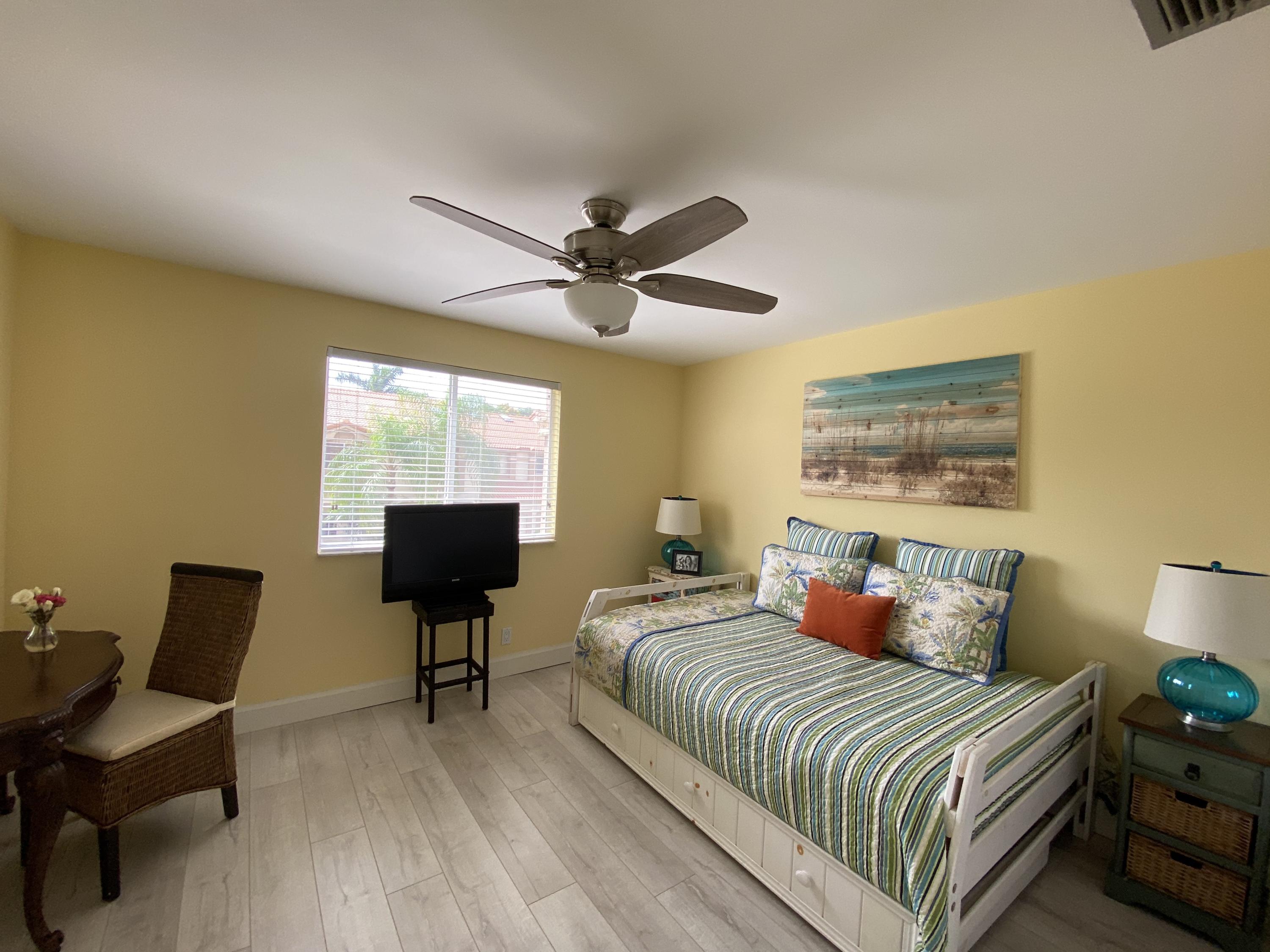 6817 Via Regina Boca Raton, FL 33433 - Photo 28 of 42 a bedroom with a bed and a chair