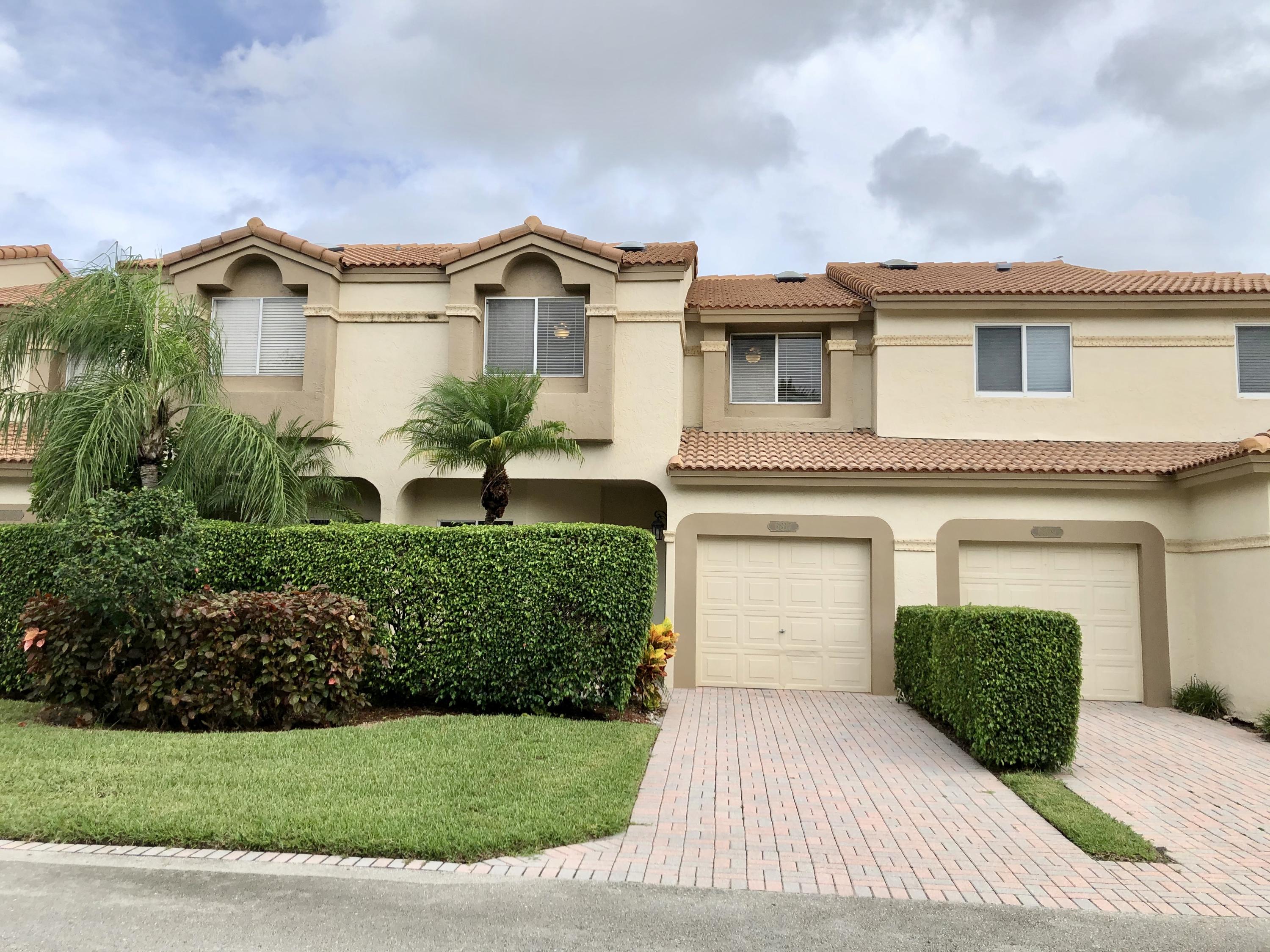 6817 Via Regina Boca Raton, FL 33433 - Photo 3 of 42 a front view of a house with a yard and garage