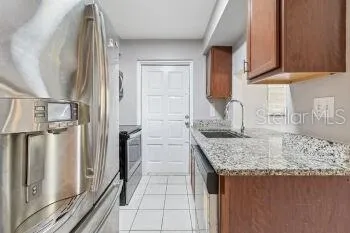 a kitchen with a granite countertop sink refrigerator and cabinets