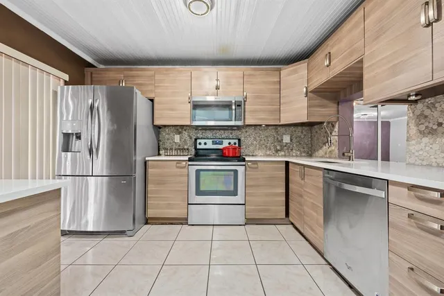 a kitchen with stainless steel appliances a refrigerator sink and cabinets
