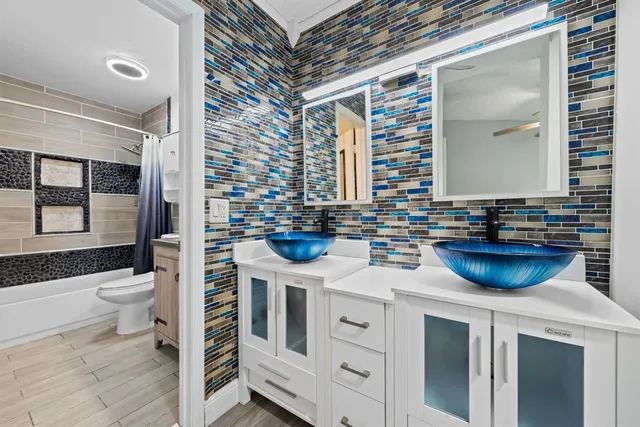 a bathroom with a sink a toilet and a mirror