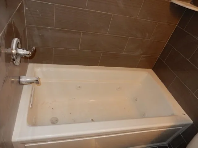 a bathroom with a bathtub shower sink and mirror