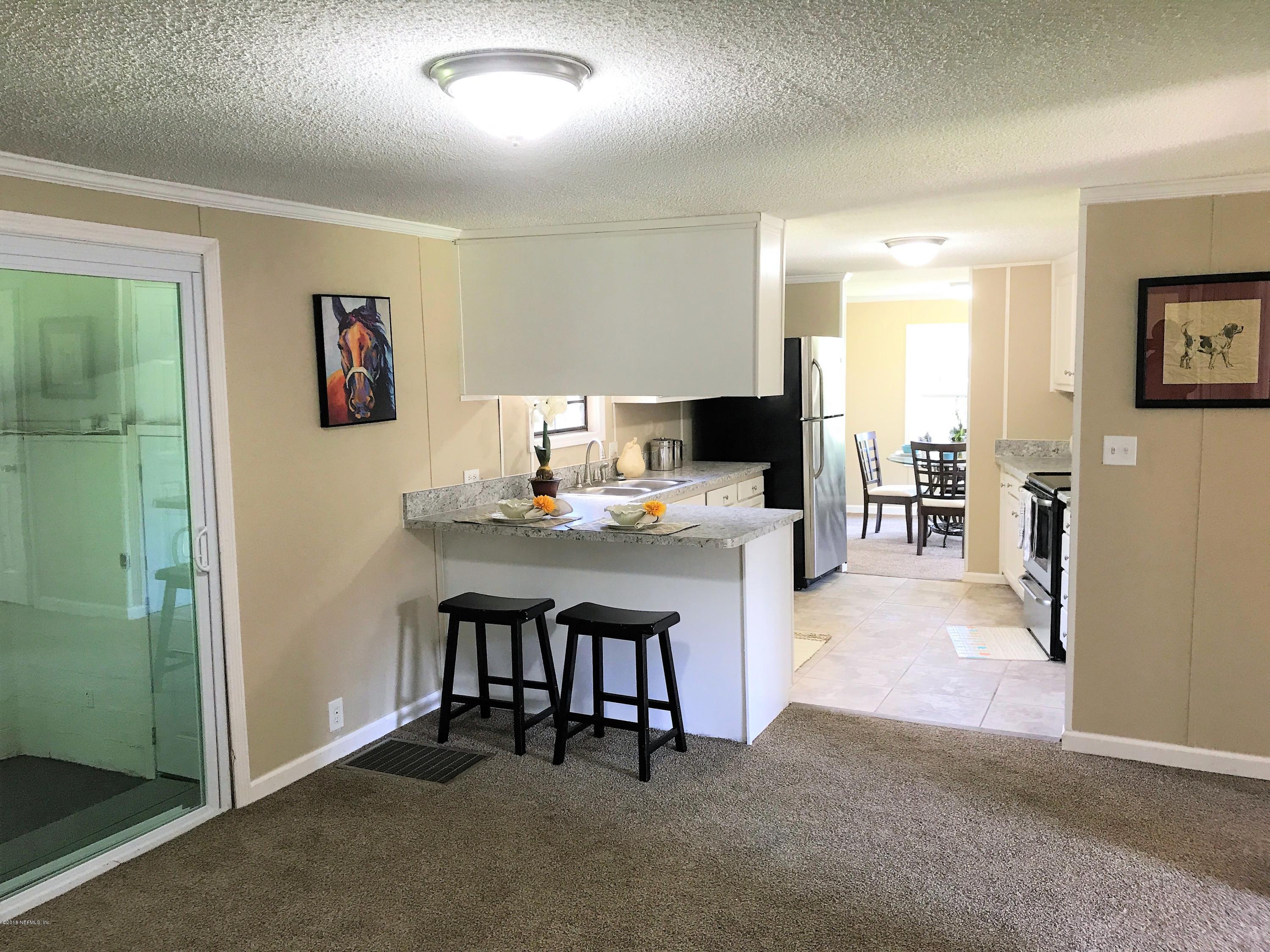 5709 North Tall Pine Road Macclenny, FL 32063 - Photo 3 of 10 a living room with furniture a dining table and kitchen view