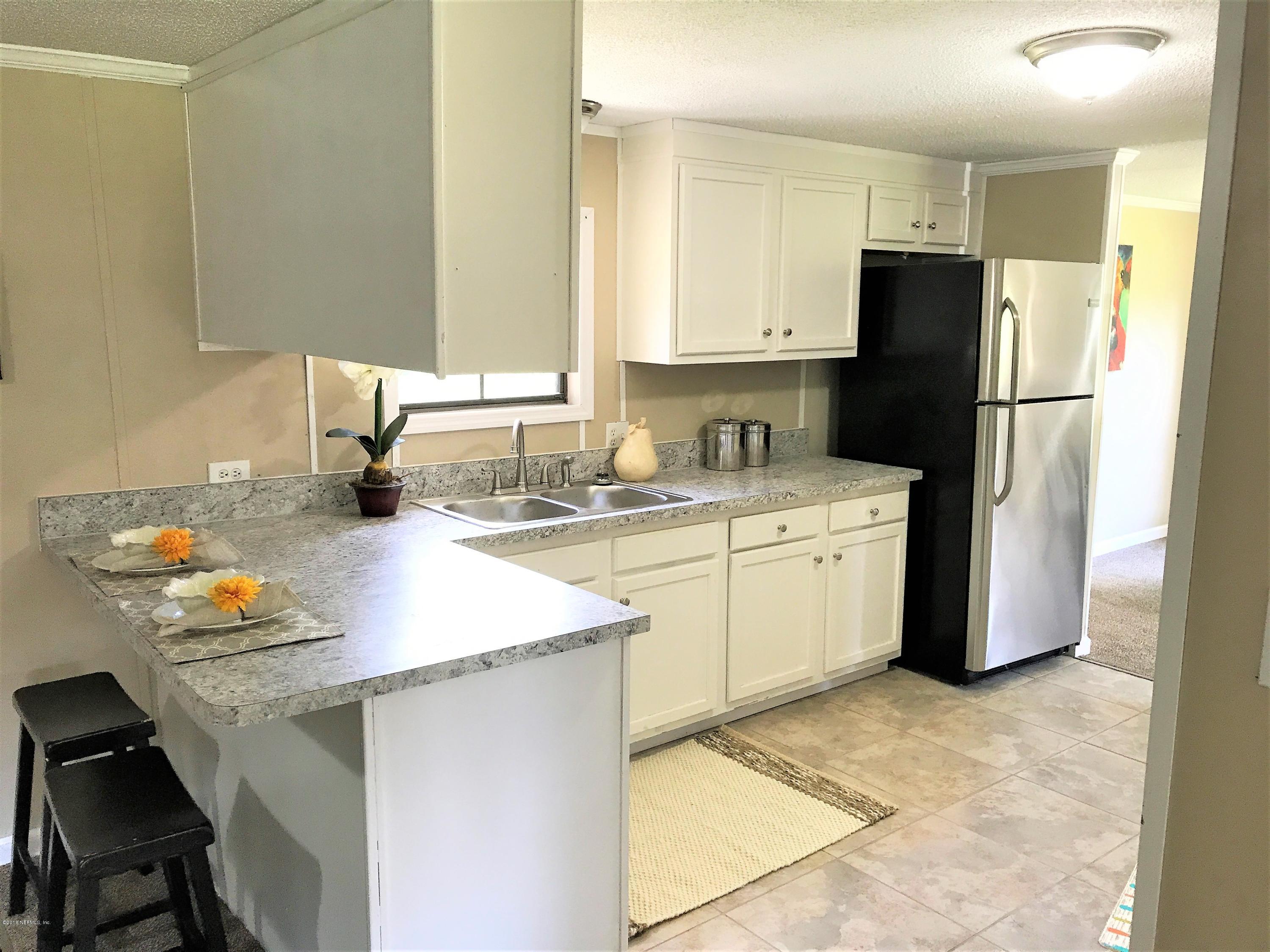 5709 North Tall Pine Road Macclenny, FL 32063 - Photo 4 of 10 a kitchen with a sink a refrigerator and a stove