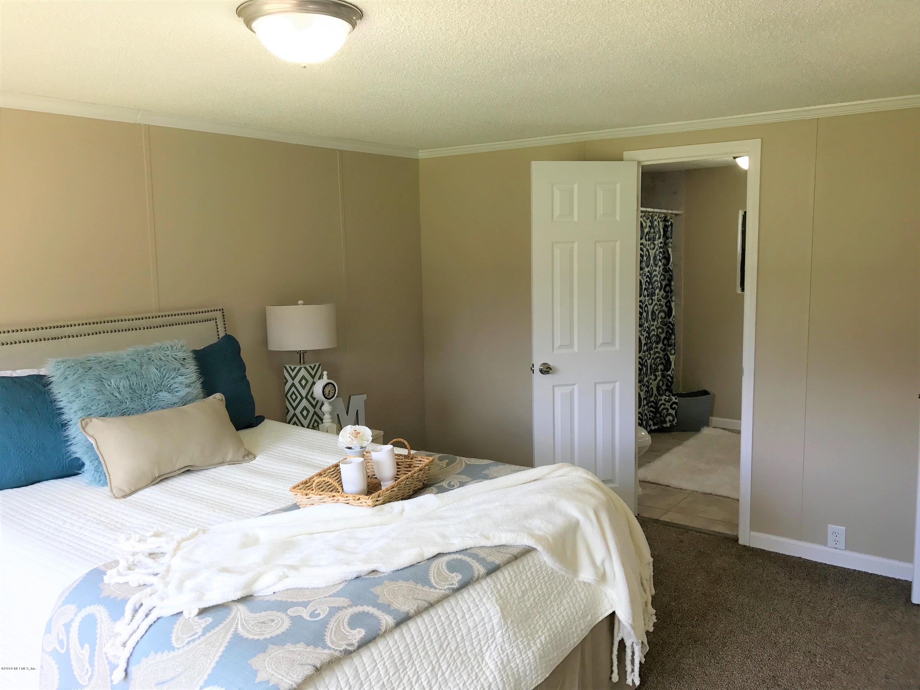 5709 North Tall Pine Road Macclenny, FL 32063 - Photo 8 of 10 a bedroom with a bed and walk in closet