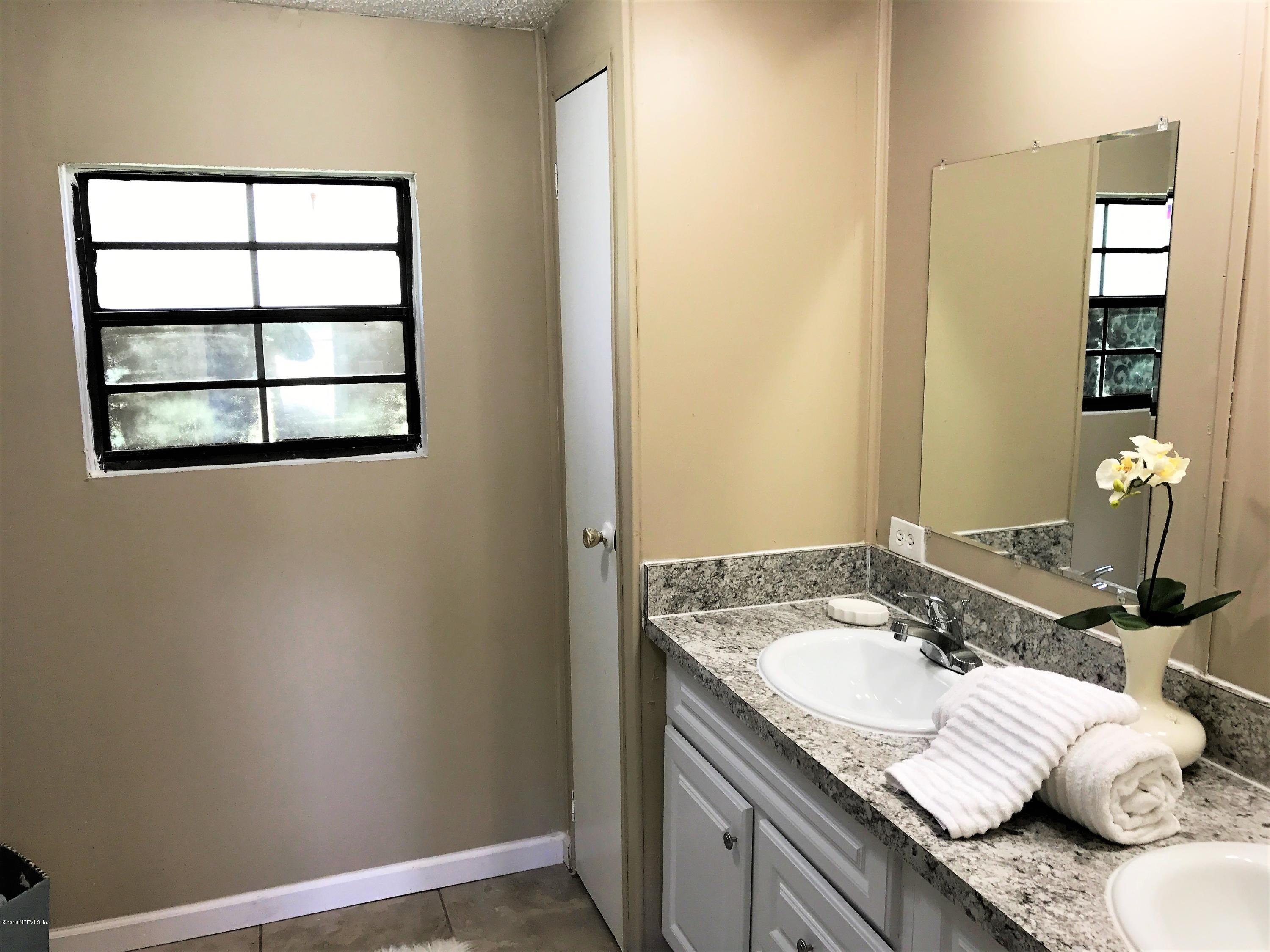 5709 North Tall Pine Road Macclenny, FL 32063 - Photo 9 of 10 a bathroom with a granite countertop sink and a mirror