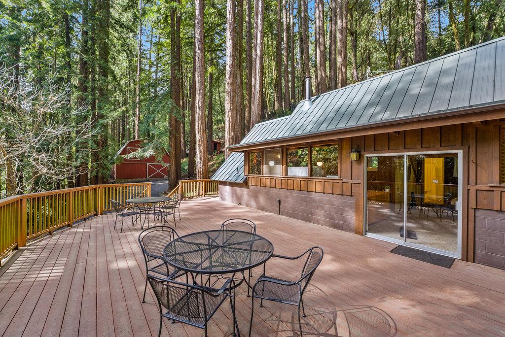a view of a patio with table and chairs with wooden floor and fence