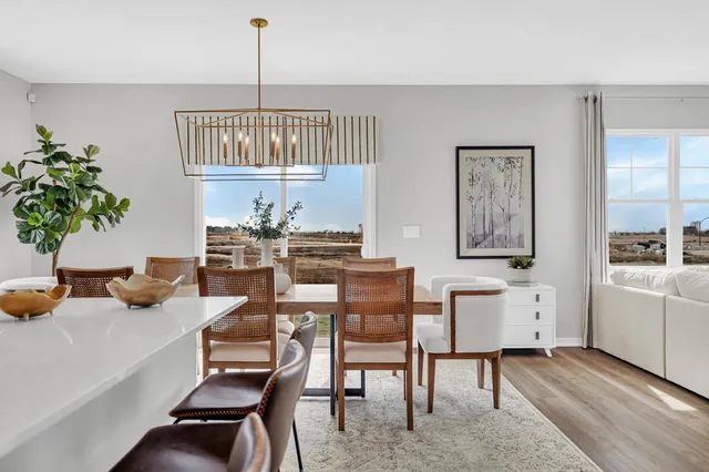 a dining room with furniture a chandelier and window