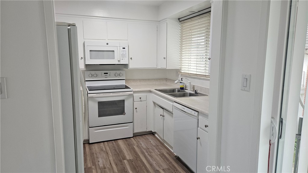 22627 Nadine Circle, Unit B Torrance, CA 90505 - Photo 3 of 16 a kitchen with granite countertop white cabinets and white appliances