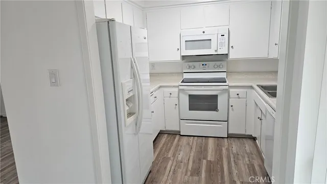 a kitchen with white cabinets and white appliances